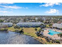 Aerial view of a waterfront community with a pool and lush landscaping at 107 Seahorse Se Dr # A, St Petersburg, FL 33705