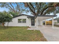 White house with carport and landscaped lawn at 4215 E Paris St, Tampa, FL 33610