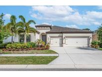 Two-story house with two-car garage, landscaping, and palm trees at 6442 Maiden Sea Dr, Apollo Beach, FL 33572