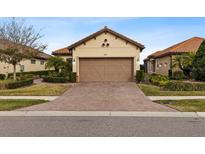 House exterior featuring a two-car garage and well-manicured landscaping at 8424 Alberata Vista Dr, Tampa, FL 33647