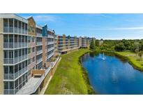 Beautiful condominiums overlooking a serene lake with a fountain and lush green surroundings at 960 Starkey Rd # 7103, Largo, FL 33771