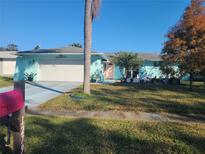 Charming light blue home with a spacious yard and mature trees at 1279 Dinnerbell E Ln, Dunedin, FL 34698