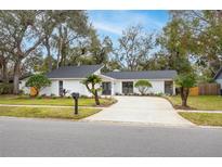 Stunning curb appeal with a renovated exterior, long driveway and lush landscaping at 3426 Reynoldswood Dr, Tampa, FL 33618