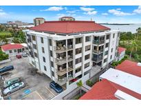 Aerial view of a condo building with red tile roofs and ample parking at 6365 Bahia Del Mar Blvd # 604, St Petersburg, FL 33715