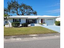 White single story home with blue shutters, attached garage, and well-maintained lawn at 9608 41St N St # 2, Pinellas Park, FL 33782