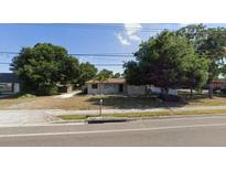Ranch-style home with a spacious yard and mature trees at 14165 Walsingham Rd, Largo, FL 33774