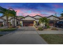 Two-story home with a brown garage door and landscaped front yard at 16909 April Plush Dr, Wimauma, FL 33598