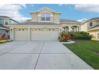 Two-story house with three-car garage and landscaped yard at 1919 Blue River Rd, Holiday, FL 34691