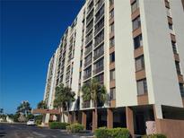 Multi-story building with parking and palm trees at 255 Dolphin Pt # 511, Clearwater Beach, FL 33767