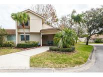 Tan house with a covered entryway, landscaping, and palm trees at 2722 Sand Hollow Ct # 2722, Clearwater, FL 33761