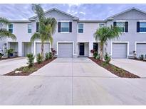 Two-story townhome with attached garage and landscaping at 32535 Turtle Grace Loop, Wesley Chapel, FL 33545