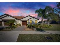 Inviting exterior of a single-story home with landscaping and a two-car garage at 5328 Stoic Vale Dr, Wimauma, FL 33598