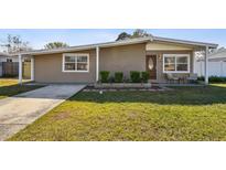 Updated ranch home with landscaped front yard and walkway at 4416 W Bay Ave, Tampa, FL 33616