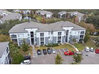 Aerial view of an apartment building with ample parking and a pond at 5513 Legacy Crescent Pl # 303, Riverview, FL 33578