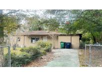 Tan brick ranch home with driveway and yard at 6405 Riverbend Cir, Tampa, FL 33610