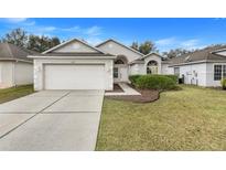 House exterior featuring a two-car garage and well-manicured lawn at 4605 Lisette Cir, Brooksville, FL 34604