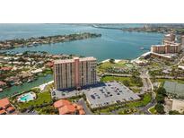 Aerial view of waterfront condo building with pool, parking, and tennis court at 4900 Brittany S Dr # 701, St Petersburg, FL 33715