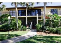 Two-story condo building with lush landscaping and walkway at 6472 Seagull Dr # 303, Bradenton, FL 34210