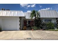 White two-story home with attached garage and landscaping at 6574 Green Valley Dr, Seminole, FL 33777
