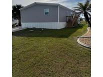 Charming home featuring gray siding, elevated design, and a well-manicured lawn at 7337 Desant Ln, Port Charlotte, FL 33981