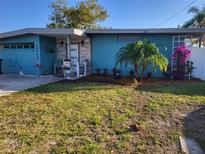 Updated teal home with landscaped yard, featuring a new front door and walkway at 16108 5Th E St, Redington Beach, FL 33708