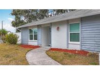 Updated exterior with walkway, landscaping, and neutral color scheme at 2058 Sheffield Ct, Oldsmar, FL 34677