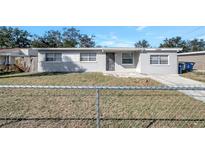 Cute bungalow with gray exterior, chain link fence, and well-maintained lawn at 10926 N Lantana Ave, Tampa, FL 33612