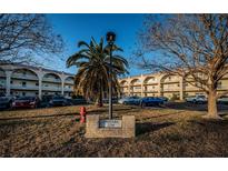 Orizaba condos complex with manicured lawn, trees, and ample parking for residents and guests at 2258 World Parkway W Blvd # 8, Clearwater, FL 33763