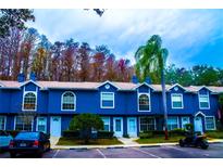 Row of charming blue townhouses with lush landscaping and ample parking at 3377 Fox Hunt Dr # B, Palm Harbor, FL 34683