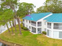 Aerial view of condo community near golf course and lake at 3609 Indigo Pond Dr, Palm Harbor, FL 34685