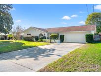 Single-story house with driveway, landscaped lawn, and attached garage at 4345 Union Springs Rd, Spring Hill, FL 34608