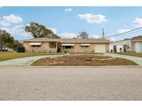 Ranch style home with a large driveway and mature landscaping at 6388 21St N Ave, St Petersburg, FL 33710