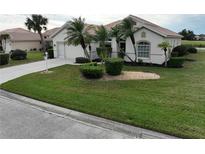 Single-story home with a landscaped lawn and palm trees at 6769 Greenview Ln, Englewood, FL 34224