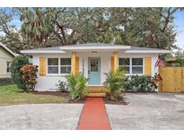 Charming white cottage with teal door, wood accents, and landscaped yard at 2242 22Nd S Ave, St Petersburg, FL 33712