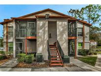 Two-story condo building with balconies and a landscaped yard at 3455 Countryside Blvd # 34, Clearwater, FL 33761