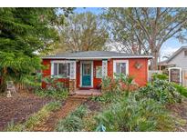 Charming red bungalow with brick pathway, lush landscaping, and a fenced yard at 4334 3Rd N Ave, St Petersburg, FL 33713