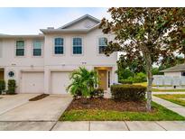 Two-story townhome with attached garage and landscaped front yard at 4533 Ashburn Square Dr # 4533, Tampa, FL 33610