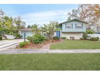 Ranch style home with light blue exterior, brick accents, and landscaped yard at 509 Oakhurst St, Brandon, FL 33511