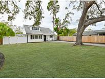 House with spacious front yard, large tree, and a newly installed fence at 5816 Woodrow Wilson Ne Blvd, St Petersburg, FL 33703