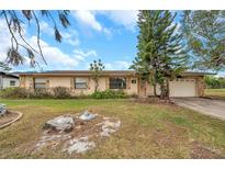 Single-story house with a brown roof, stone accents, and a spacious yard at 6327 5Th Street E Cir, Bradenton, FL 34203