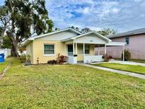 Cute yellow house with a well-maintained lawn at 963 27Th S Ave, St Petersburg, FL 33705