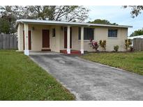 Ranch-style home with carport, landscaped lawn, and mature trees at 11798 104Th St, Largo, FL 33773