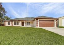 Single-story house with brown garage door and green lawn at 1360 Franklin Ln, North Port, FL 34286