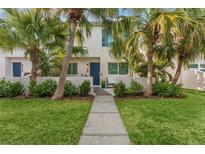 Bright and airy home with a walkway leading to a blue door, surrounded by lush tropical landscaping at 4208 Harbor House Dr, Tampa, FL 33615