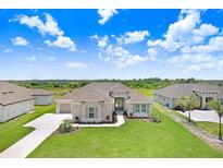 Beautiful single-story home showcasing a well-manicured lawn, beige exterior, and charming curb appeal at 5214 Lake Venice Dr, Wimauma, FL 33598