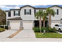 Two-story townhome with attached garage and landscaping at 21428 Darter Rd, Land O Lakes, FL 34638