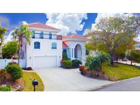 Two-story house with a three-car garage and manicured landscaping at 301 Midway Is, Clearwater Beach, FL 33767