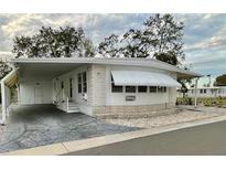 White single-wide manufactured home with carport and landscaped yard at 34212 Canal N Dr # B, Pinellas Park, FL 33781