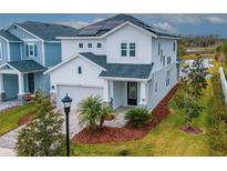 Two-story house with solar panels, paver driveway, and landscaped lawn at 3715 Front Park Dr, Wesley Chapel, FL 33543