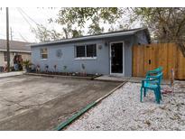Cute bungalow with a small front yard, a concrete driveway, and a wooden fence at 438 E Martin Luther King Jr Dr, Tarpon Springs, FL 34688